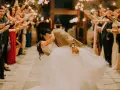 La sposa e lo sposo si baciano tra le scintille dei bengala, circondati da amici e parenti festanti. Un momento magico che sembra uscito da un gioco.