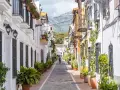 Un vicolo pittoresco con case bianche e colorate, balconi fioriti e piante in vaso. Un assaggio di cosa vedere a Marbella, tra fascino e tradizione.