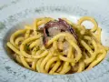 Bucatini con acciughe e cipolla, un classico tra i piatti tipici di Padova, conditi con prezzemolo fresco.