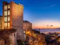 Torre medievale illuminata al tramonto, con vista sul porto e sul mare. Un'ottima anteprima di cosa vedere a Cagliari in un giorno.