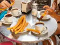 Assaporare i churros con cioccolata calda è un must per sapere cosa mangiare a Madrid. Un'esperienza golosa da condividere.