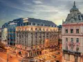 Hotel Astoria, un'ottima scelta per dove alloggiare a Budapest, si affaccia su una strada trafficata con auto gialle sfocate.