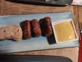 Mici e pane: un assaggio di cosa mangiare a Bucarest. Salsicce grigliate servite con pane fresco e senape.
