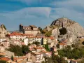 Borgo arroccato con case dai tetti rossi, una chiesa imponente e una roccia con croce in cima. Un luogo da scoprire tra le meraviglie di cosa vedere in Molise.