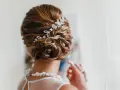 Splendida acconciatura alta sposa con fermaglio scintillante e collana di perle.