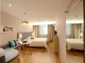 Camera accogliente con letto, divanetto e laptop, ideale per sapere dove alloggiare ad Amsterdam.