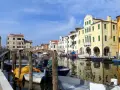 Chioggia cosa vedere: un canale con barche ormeggiate e case colorate che si riflettono sull'acqua.