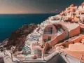 Case bianche e blu aggrappate alla scogliera di Santorini, un sogno per chi cerca cosa fare a Santorini in 7 giorni.