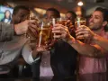 Amici brindano con birra in un locale, un brindisi per l'addio al celibato.