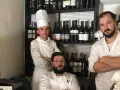 Tre chef posano davanti a una cantina di vini in un ristorante stellato Puglia.