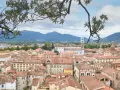 Panoramica di Lucca con tetti rossi e montagne sullo sfondo. Ideale per scoprire cosa vedere in un giorno.