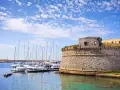 Porto di Gallipoli con castello e barche a vela. Un luogo incantevole per scoprire cosa fare a Gallipoli.