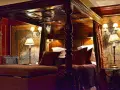 Lussuosa camera da letto con letto a baldacchino, arazzi storici e lampade eleganti. Un'idea di dove dormire a Edimburgo per un soggiorno da re.