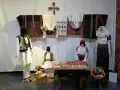 A Bucarest a dicembre, un'esposizione di abiti tradizionali rumeni, con manichini che indossano ricchi ricami e tessuti colorati.