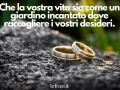 Due fedi nuziali su una roccia, con la frase "Che la vostra vita sia come un giardino incantato dove raccogliere i vostri desideri". Promesse d'amore frasi.