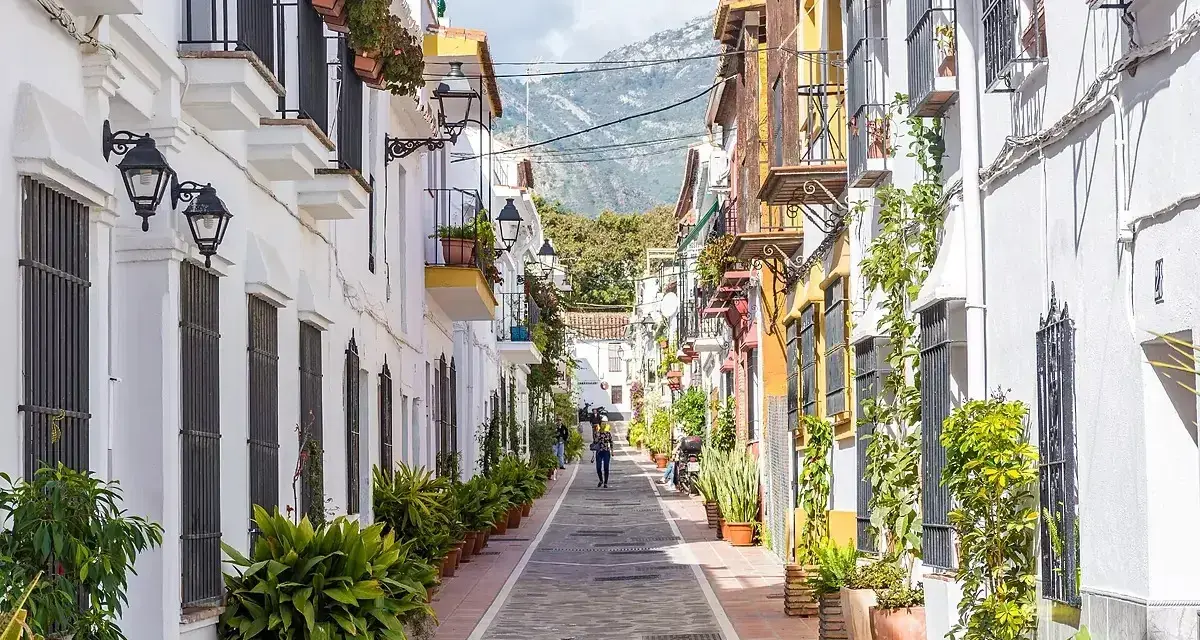 Un vicolo pittoresco con case bianche e colorate, balconi fioriti e piante in vaso. Un assaggio di cosa vedere a Marbella, tra fascino e tradizione.