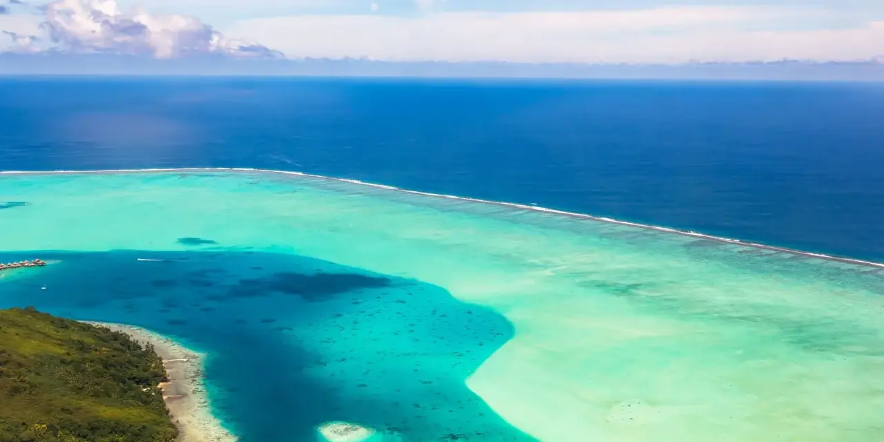 Un'isola lussureggiante si affaccia su acque turchesi e blu intenso. Perfetto per chi cerca il mare a gennaio dove andare.