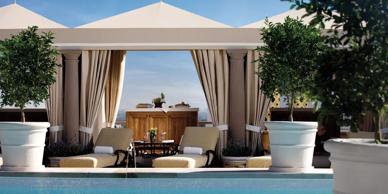 Rilassati in piscina a Los Angeles. Due lettini prendisole e alberi in vaso creano un'oasi perfetta per sapere dove dormire a Los Angeles.