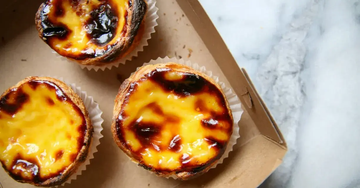 Pastéis de nata appena sfornati, un must per scoprire cosa mangiare a Lisbona. Croccanti fuori, cremosi dentro.