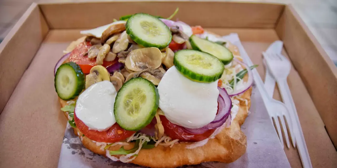 Lángos, un fritto ungherese con pomodoro, mozzarella, cetrioli e funghi. Un'ottima idea per cosa mangiare a Budapest.