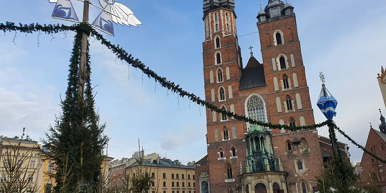 Mercatino natalizio a Cracovia, con la Basilica di Santa Maria in sottofondo. Perfetto per trovare dove dormire a Cracovia.