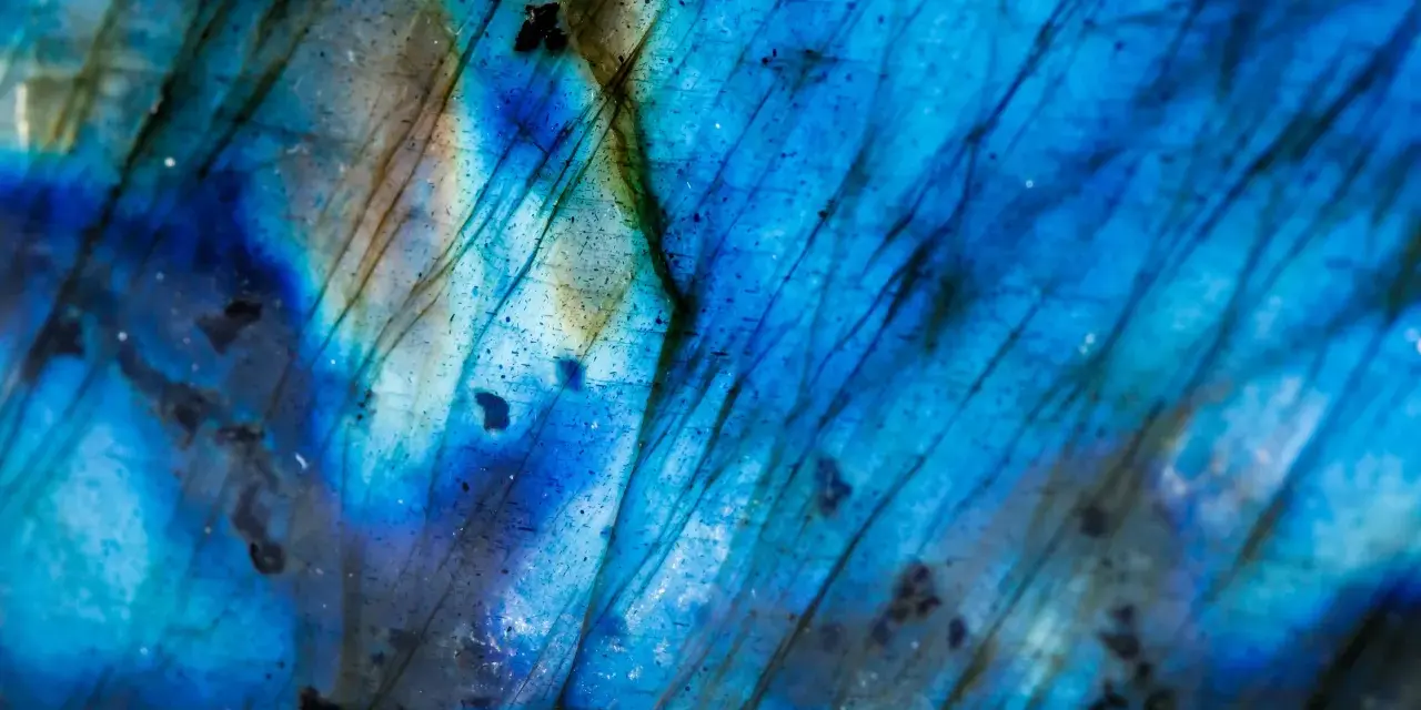 Dettaglio di un feldspato labradorite con riflessi blu elettrico e striature scure, un vero tesoro per le nozze.