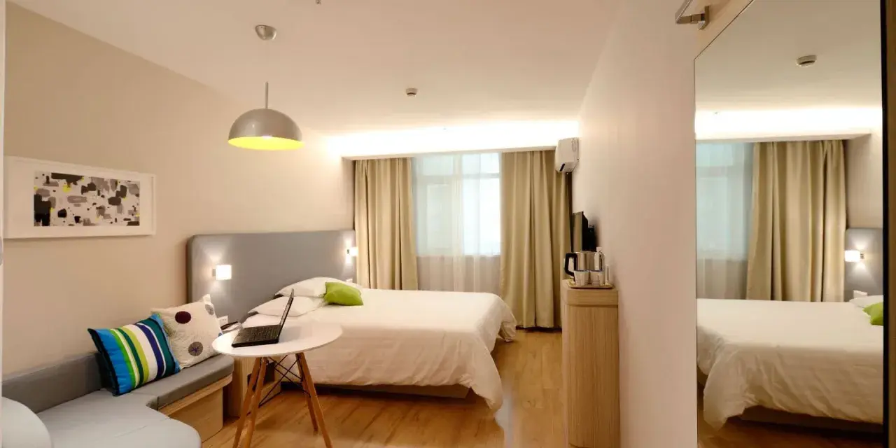 Camera accogliente con letto, divanetto e laptop, ideale per sapere dove alloggiare ad Amsterdam.