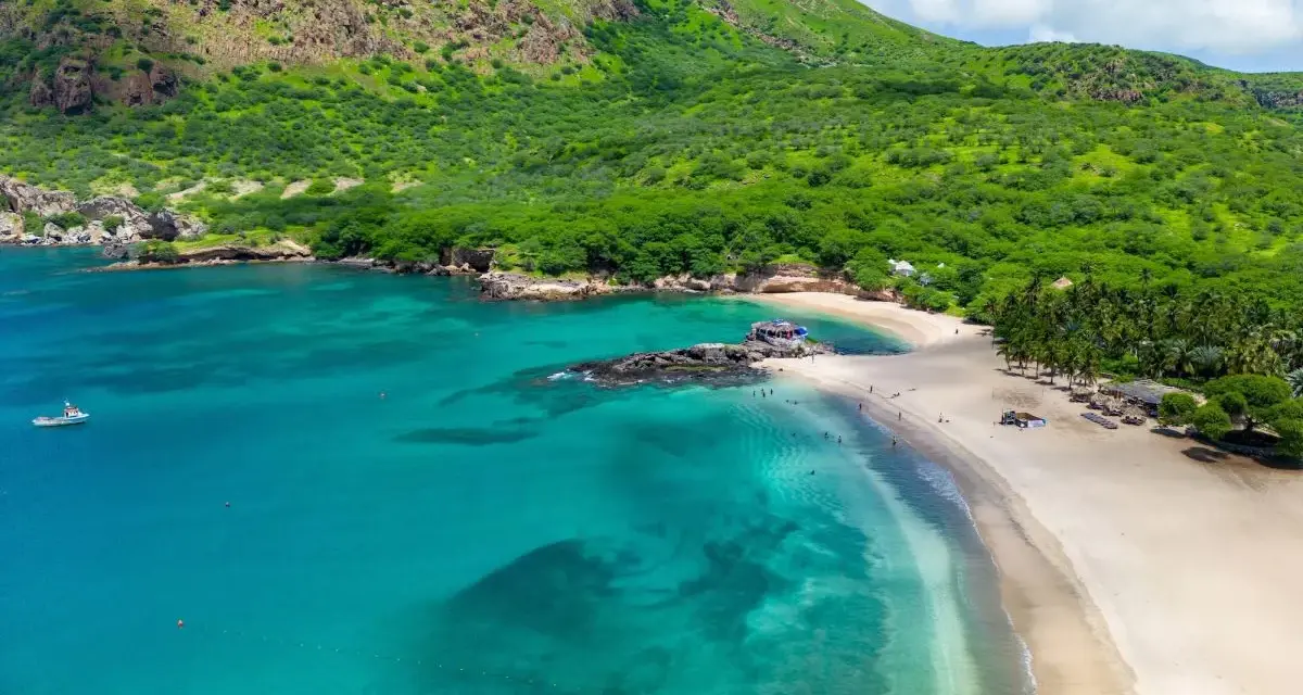 Spiaggia tropicale con mare turchese e montagne verdi. Un vero capo verde, ideale per una vacanza da sogno.