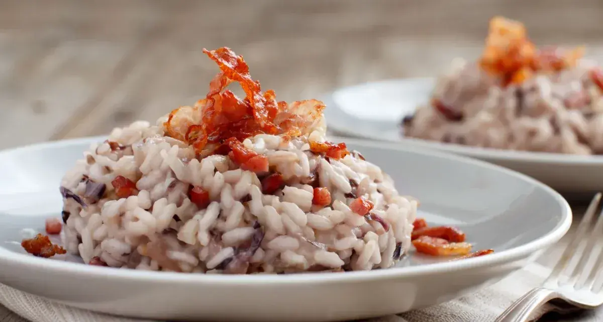Risotto cremoso con radicchio e pancetta croccante, un classico da provare se ti chiedi cosa mangiare a Treviso.