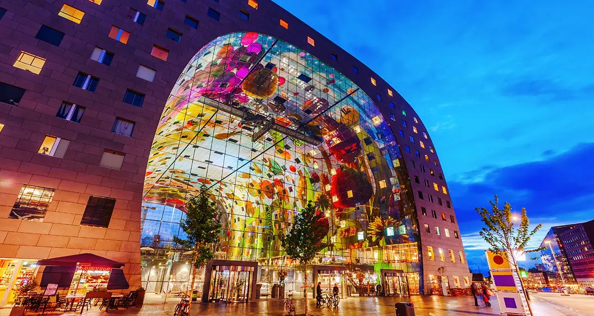 Il Markthal di Rotterdam, un'opera architettonica mozzafiato con un soffitto decorato, è un luogo imperdibile da vedere.