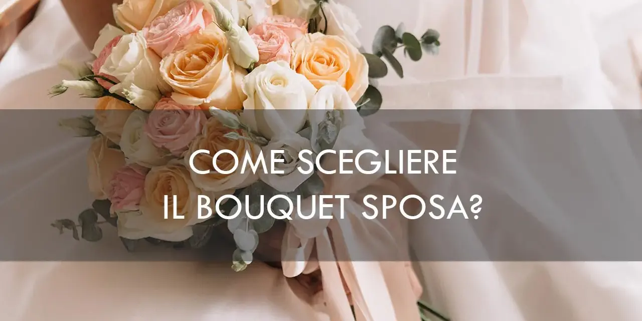 Un bouquet sposa elegantissimo con rose pesca, rosa e bianche, tenuto da una sposa.