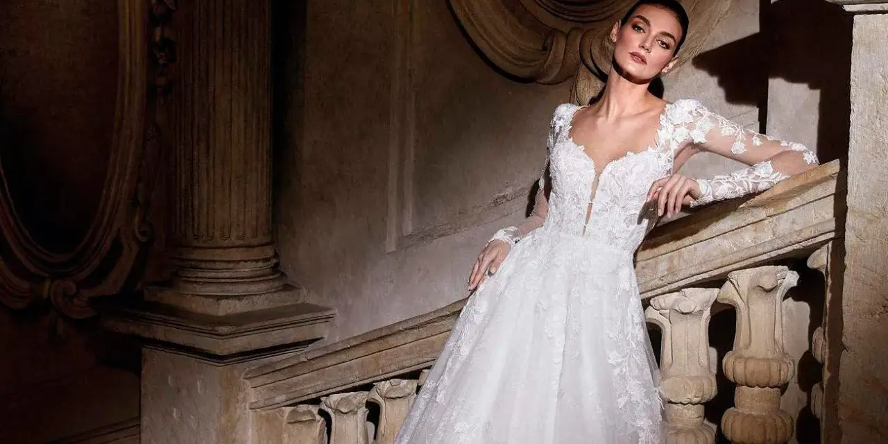 Modella con abiti da sposa per sembrare più alte, posa su una scala di pietra antica.
