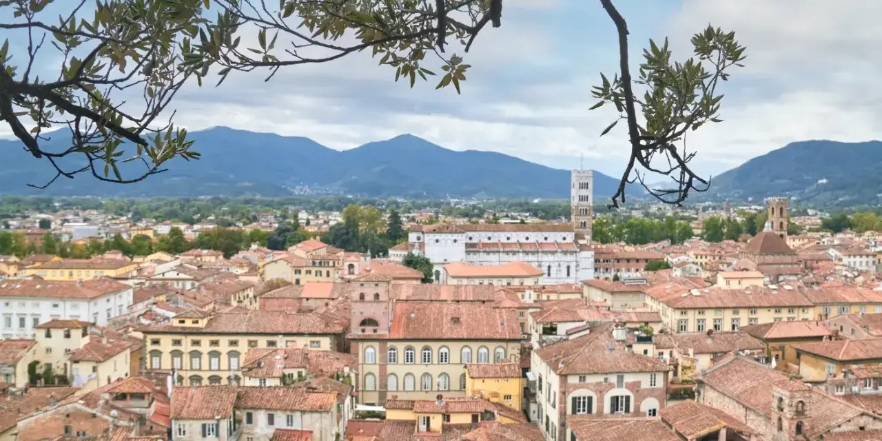 Panoramica di Lucca con tetti rossi e montagne sullo sfondo. Ideale per scoprire cosa vedere in un giorno.