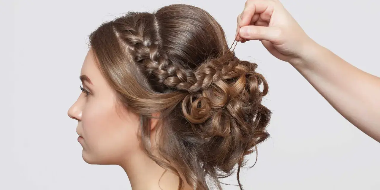 Treccia semiraccolto, un'acconciatura sposa elegante con ricci morbidi e una mano che aggiunge un fermaglio.