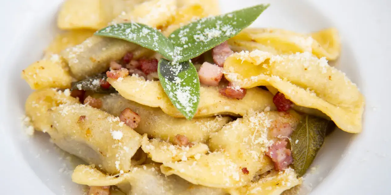Casoncelli alla bergamasca, un classico su cosa mangiare a Bergamo, con pancetta, salvia e abbondante parmigiano.