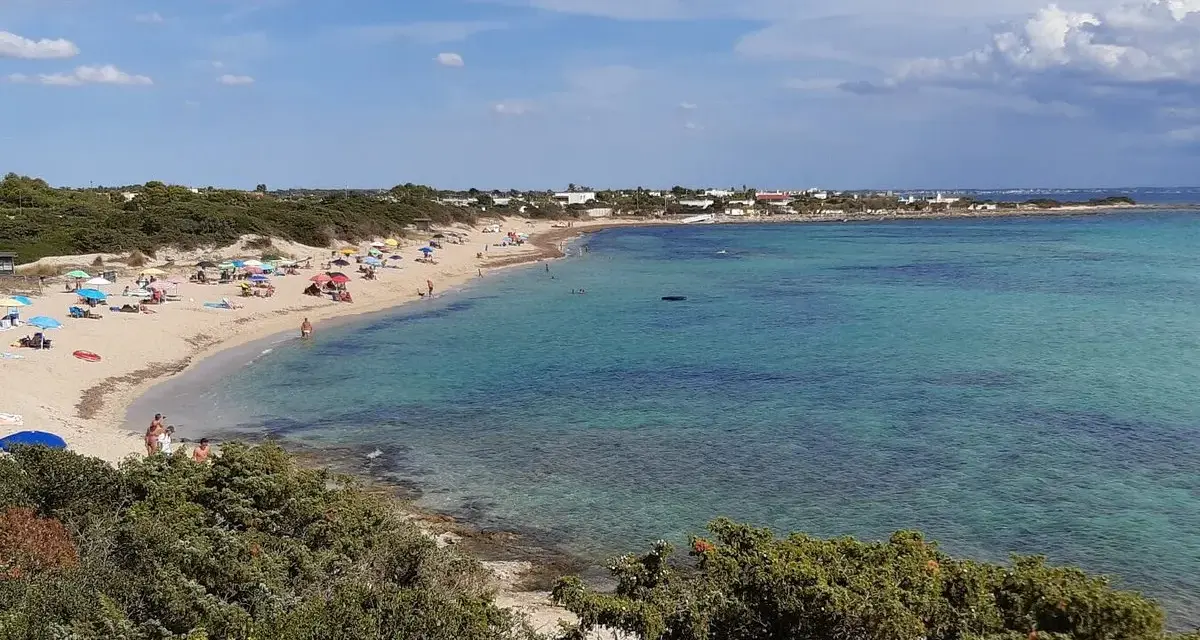 Spiaggia di Punta Prosciutto, Salento. Acque cristalline e sabbia dorata, ideale per una vacanza. Prezzi accessibili per godersi il mare.