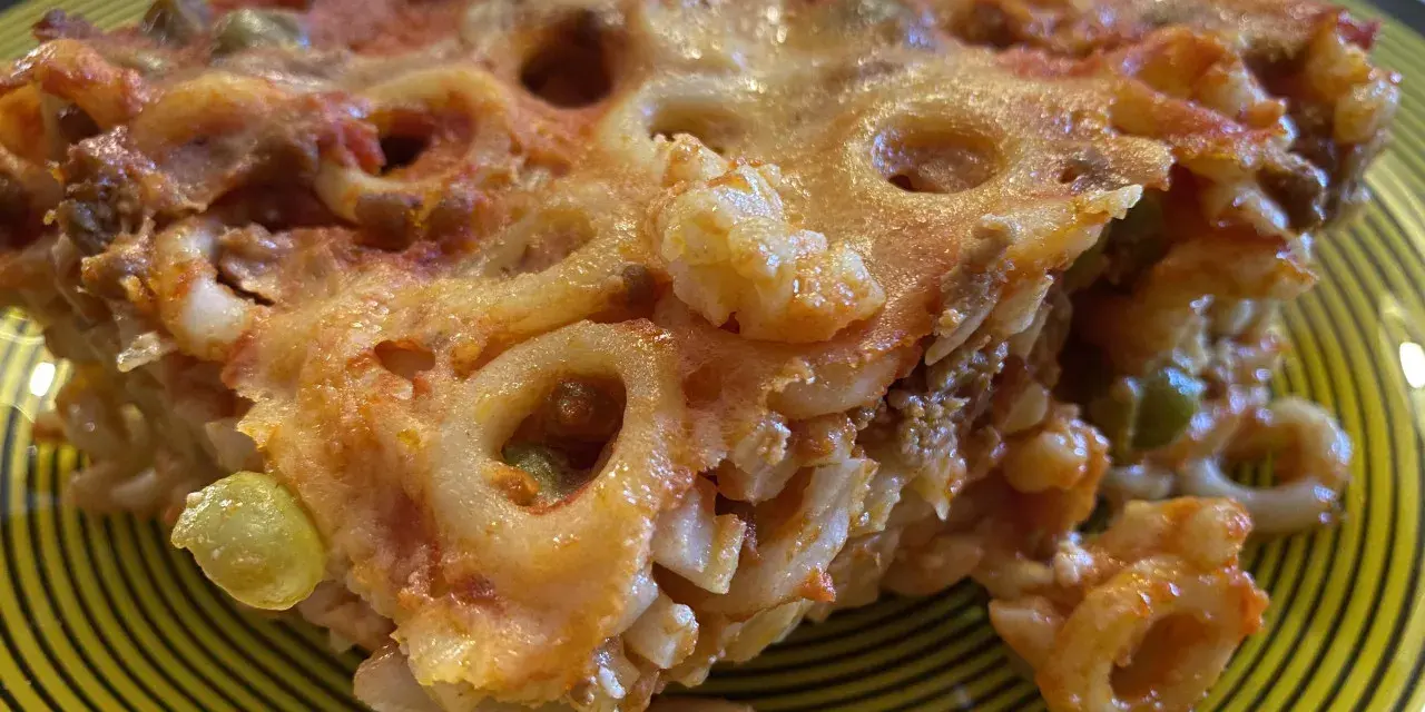 Un pezzo di pasta al forno con ragù e piselli, un'idea gustosa per cosa mangiare a Palermo.