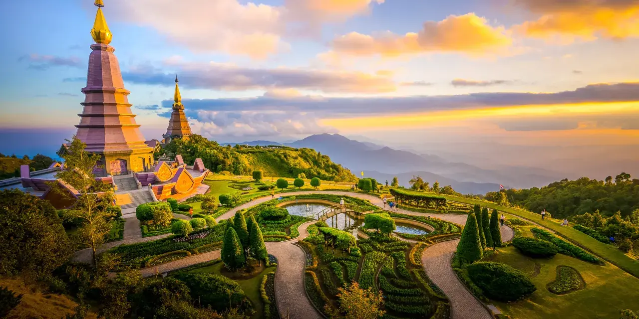 Templi dorati su una collina verdeggiante, con giardini curati e montagne all'orizzonte. Un luogo imperdibile tra le cose da vedere a Chiang Mai.