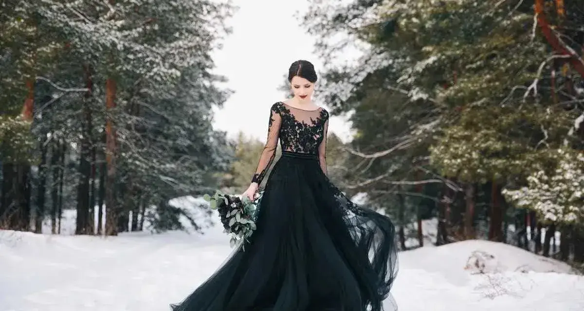 Una sposa in un bosco innevato indossa un abito da sposa nero, un simbolo di audacia e individualità.