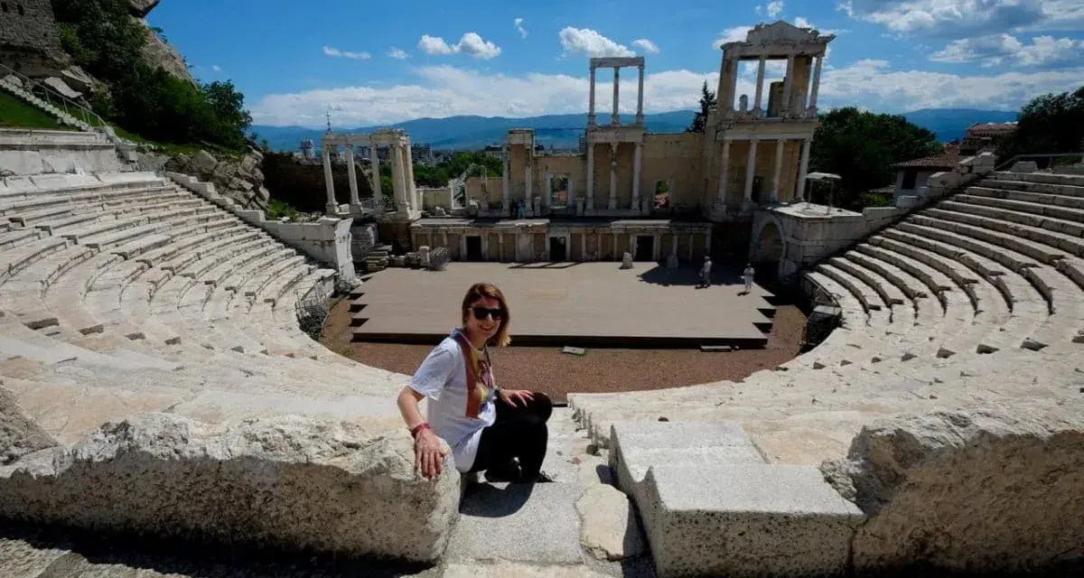 Donna sorride nell'antico teatro romano, un must per chi visita Plovdiv cosa vedere.