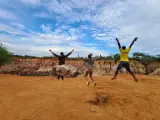 Tre amici saltano felici in Kenya, un'esperienza indimenticabile che vale ogni euro del costo safari Kenya.
