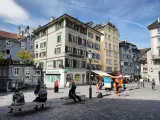 Piazza di Zurigo con edifici colorati, negozi e persone che passeggiano. Ideale per scoprire cosa vedere a Zurigo in un giorno.