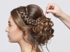 Treccia semiraccolto, un'acconciatura sposa elegante con ricci morbidi e una mano che aggiunge un fermaglio.