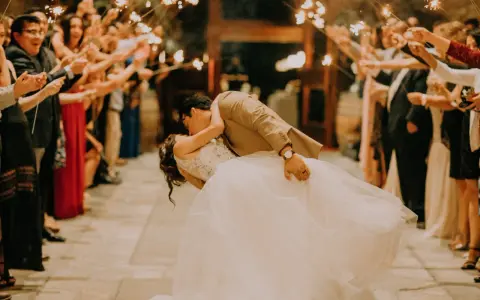 La sposa e lo sposo si baciano tra le scintille dei bengala, circondati da amici e parenti festanti. Un momento magico che sembra uscito da un gioco.