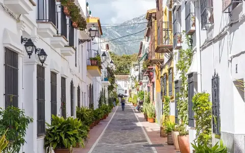 Un vicolo pittoresco con case bianche e colorate, balconi fioriti e piante in vaso. Un assaggio di cosa vedere a Marbella, tra fascino e tradizione.