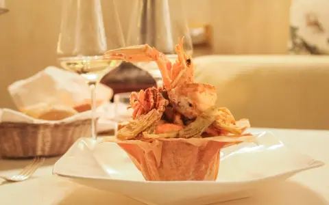 Frittura di pesce croccante, un'ottima idea per dove mangiare a Padova spendendo poco. Accompagnata da vino bianco e pane fresco.