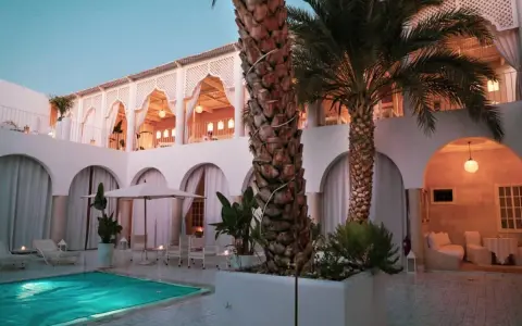 Un'oasi di pace per sapere dove dormire a Marrakech: piscina, palme e architettura moresca creano un'atmosfera magica.