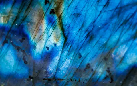 Dettaglio di un feldspato labradorite con riflessi blu elettrico e striature scure, un vero tesoro per le nozze.