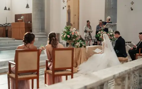 Sposi in chiesa, con la sposa in abito bianco e il velo. Si possono avere 6 testimoni di nozze, ma qui ne vediamo solo alcuni.