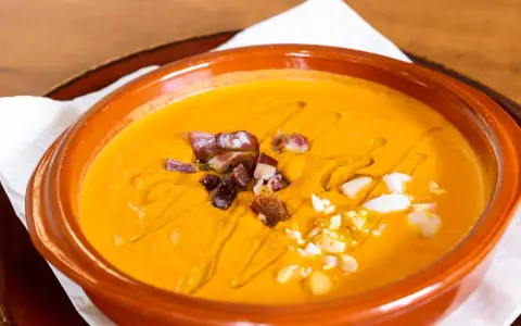 Gazpacho and salmorejo: ecco cosa mangiare a Siviglia per un'esperienza culinaria autentica. Gusta questa crema fredda con dadini di prosciutto e uovo sodo.